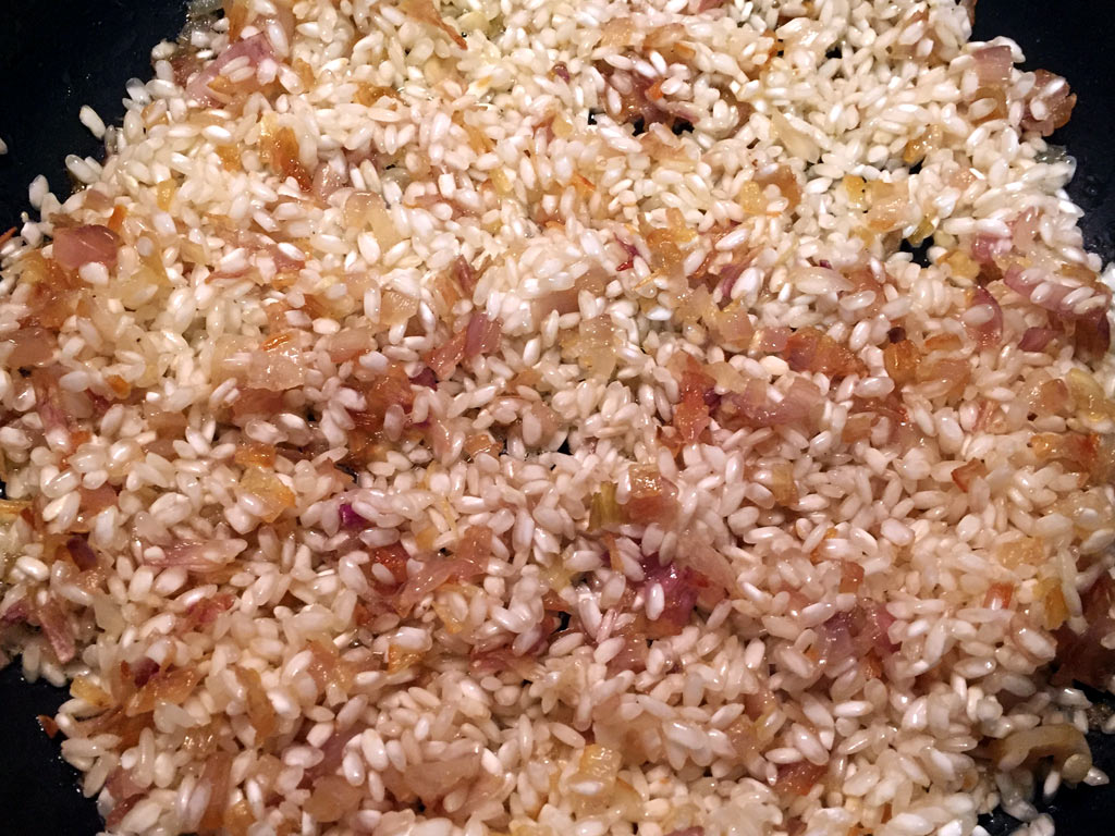 Añadir arroz a la sartén y dejar 2 minutos sin dejar de remover